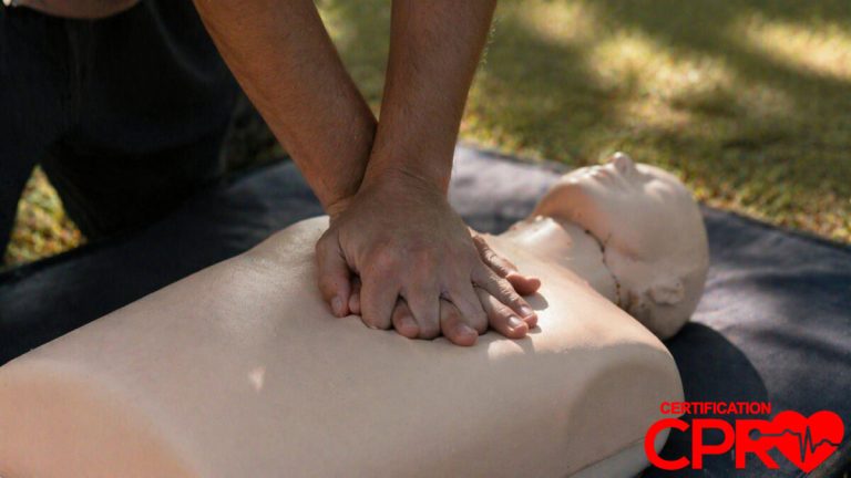 Person performing hands-only CPR on a mannequin outdoors in Lakeland.